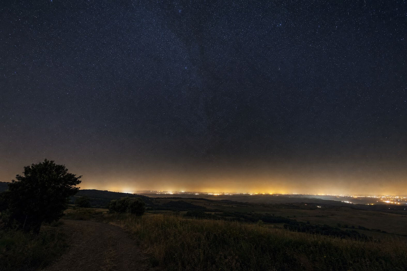 Dark rural night sky above the glow of a distant city