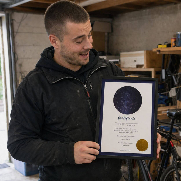 Man in his workshop proudly showing his framed Name a Star certificate